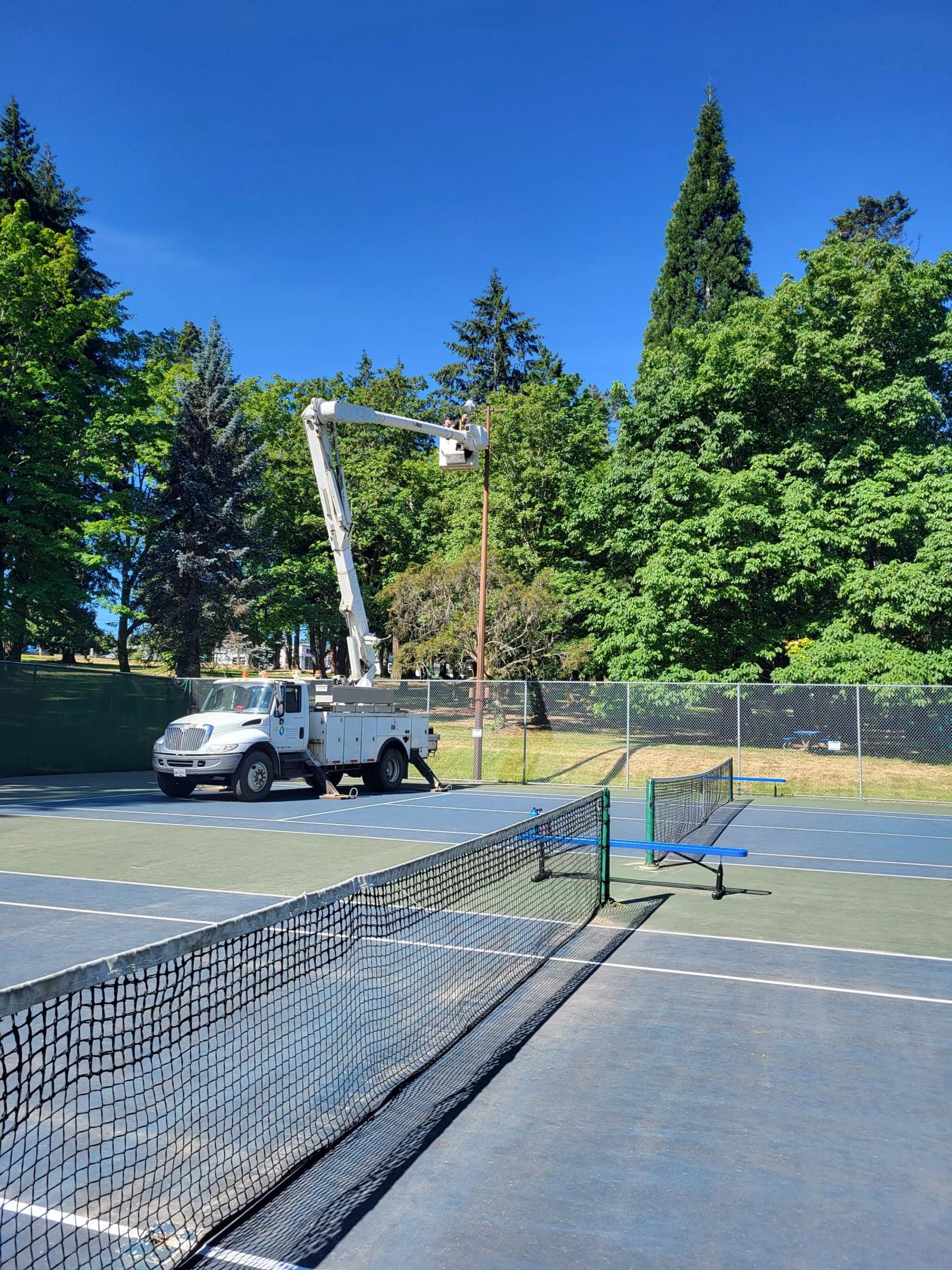 Bucket truck servicing LED sports lighting upgrade at Bowen Park tennis courts, City of Nanaimo