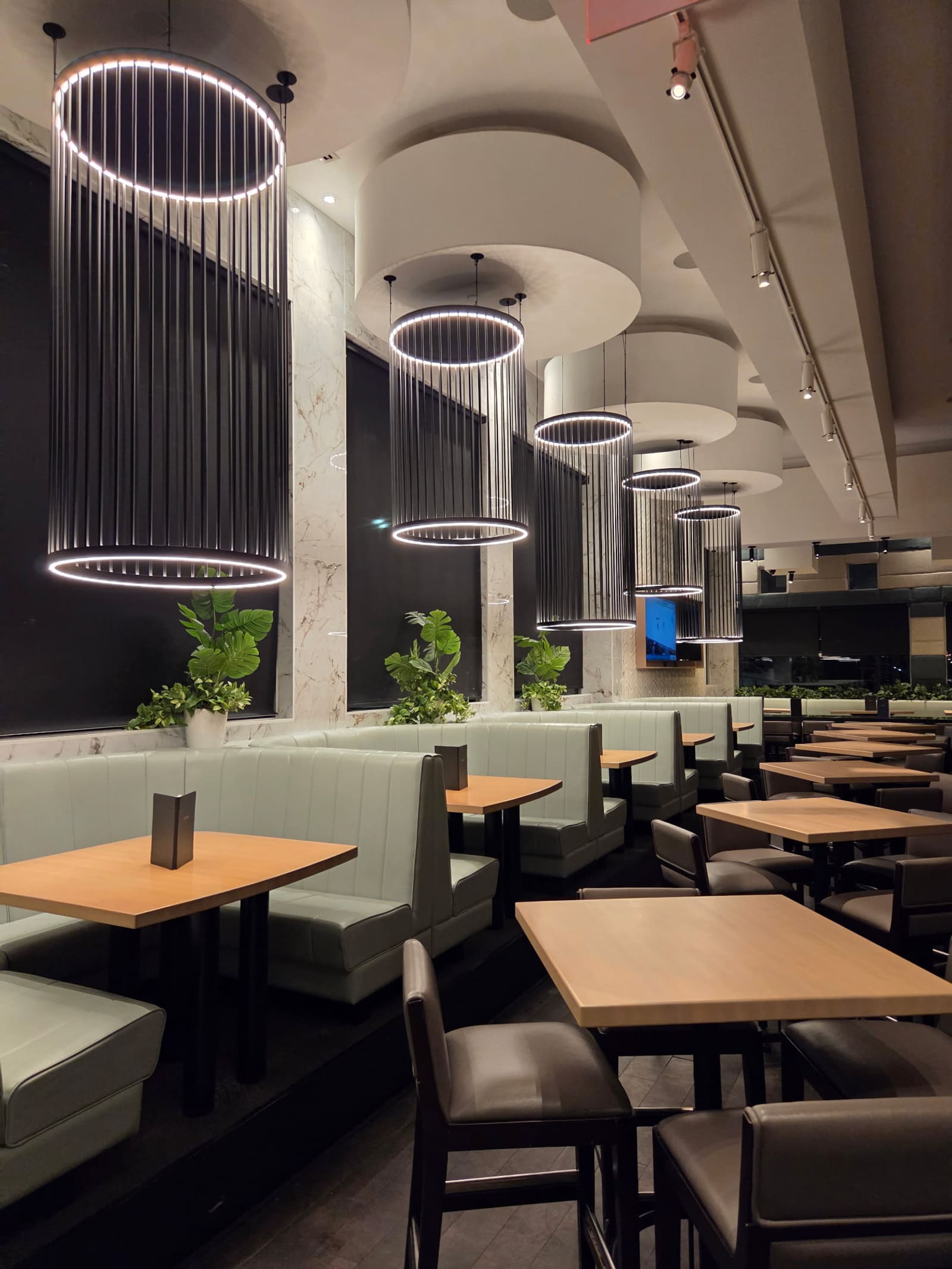 Ring pendant light fixtures installed above restaurant booths